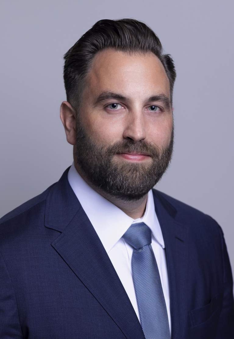 bearded business executive against a grey background
