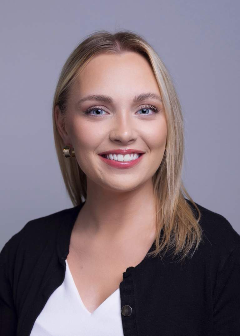 blond female corporate marketing associate against a grey background